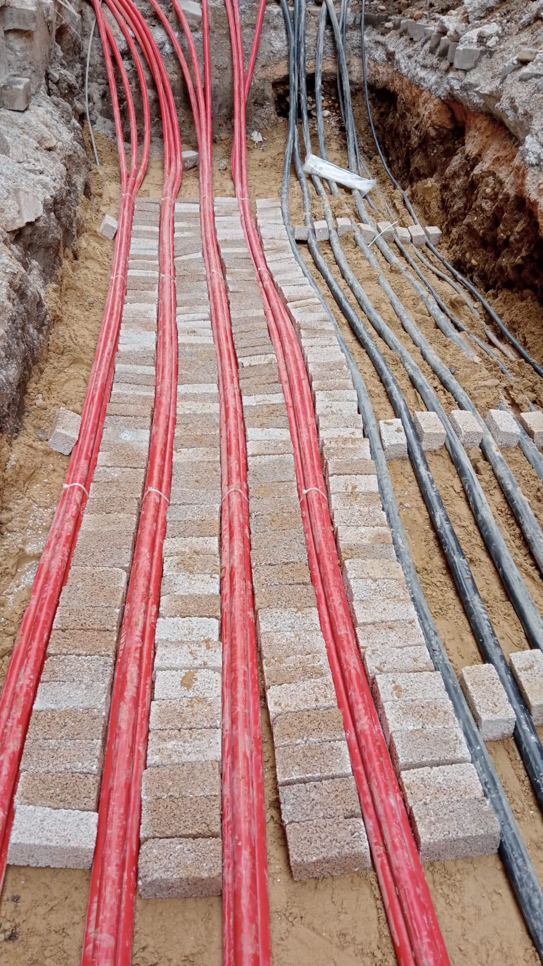 Kablo kanalına döşenmiş kırmızı ve siyah yer altı enerji kabloları